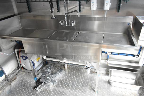Stainless steel commercial sink setup inside a Rock Solid Cargo mobile kitchen trailer, fully equipped for fast food operations.