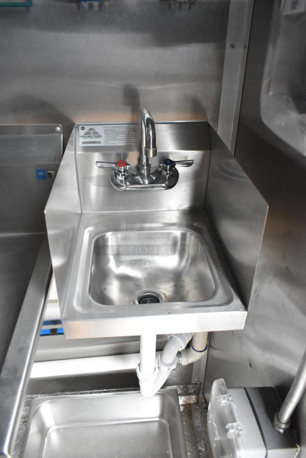 Stainless steel sink with dual-handle faucet in a Rock Solid Cargo mobile kitchen trailer. Clean, commercial-grade setup.