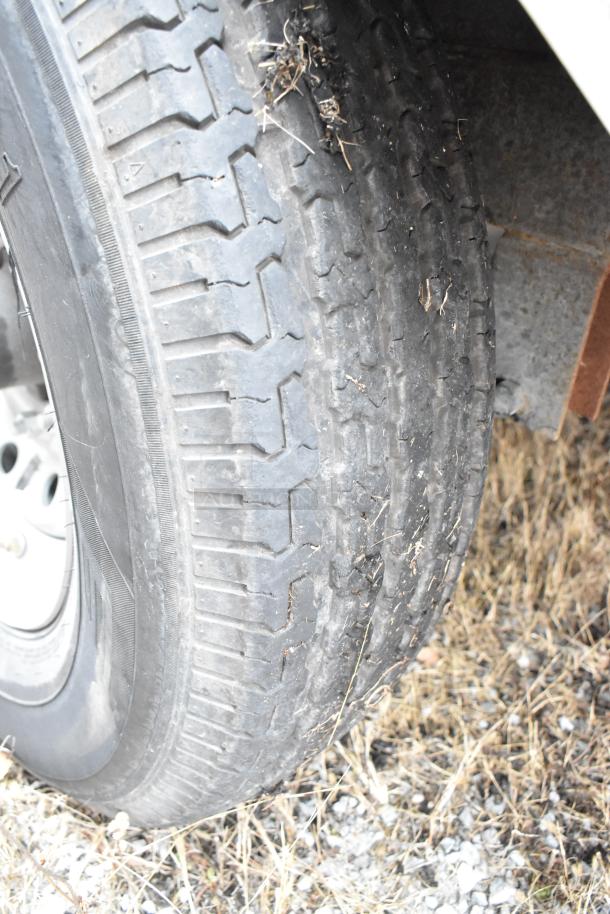 Close-up of a tire from a 2021 Rock Solid Cargo 24' mobile kitchen trailer. Visible wear and outdoor use.