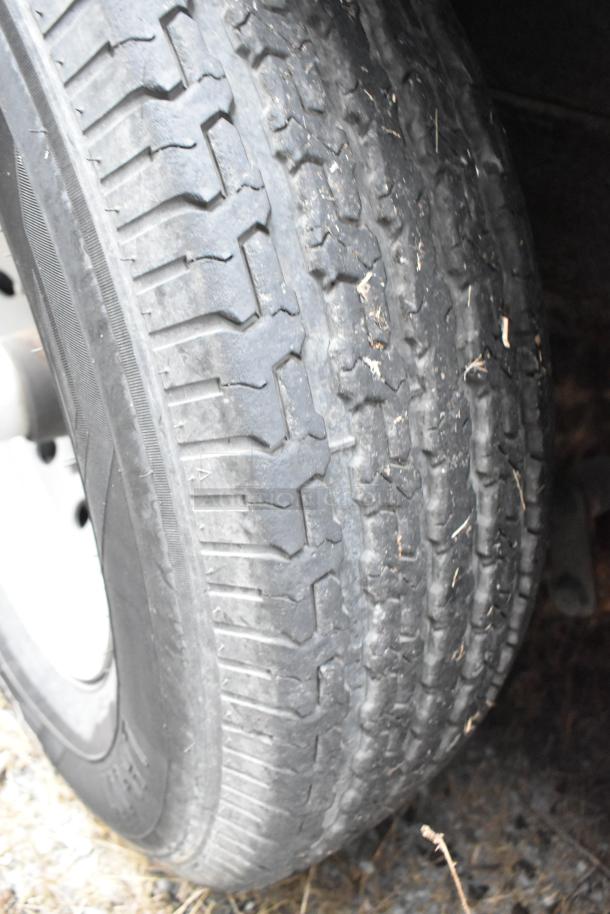 Close-up of a tire from a Rock Solid Cargo 24' mobile kitchen trailer. The tire appears to be in used condition with visible tread patterns.