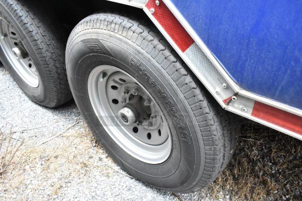 Close-up of a Ridgway Sport ST tire on a Rock Solid Cargo trailer, showing the wheel and tread in good condition.