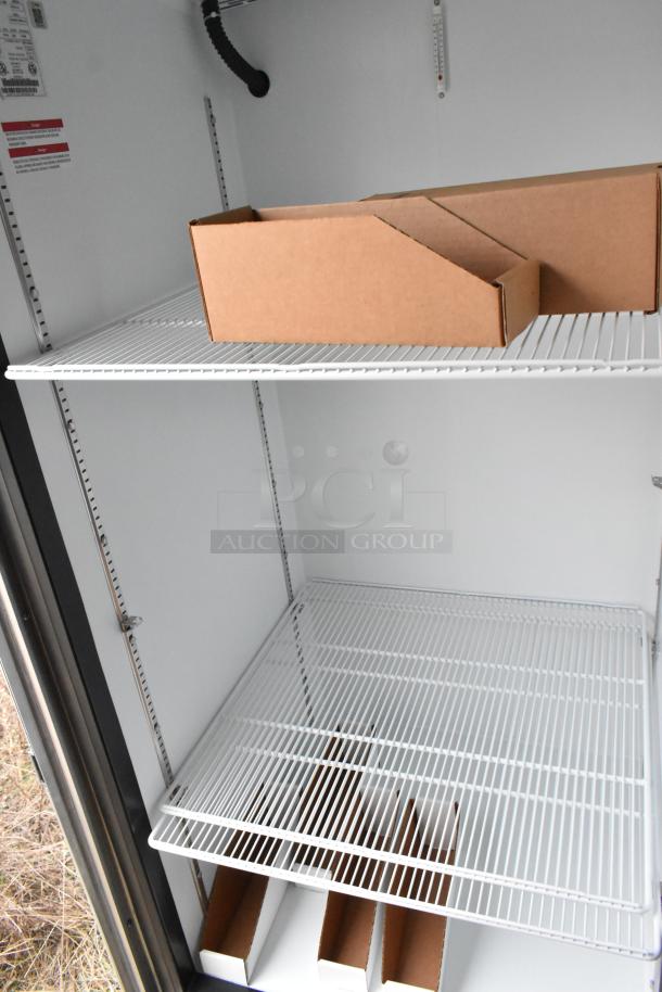 Interior of Nationwide food trailer with wire shelving, cardboard boxes, and appliance labels visible.