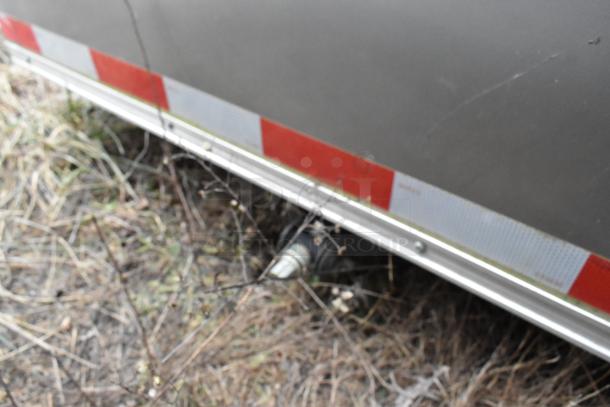 Close-up of the lower exterior of a Nationwide 24' food trailer, showing red and white reflective tape.