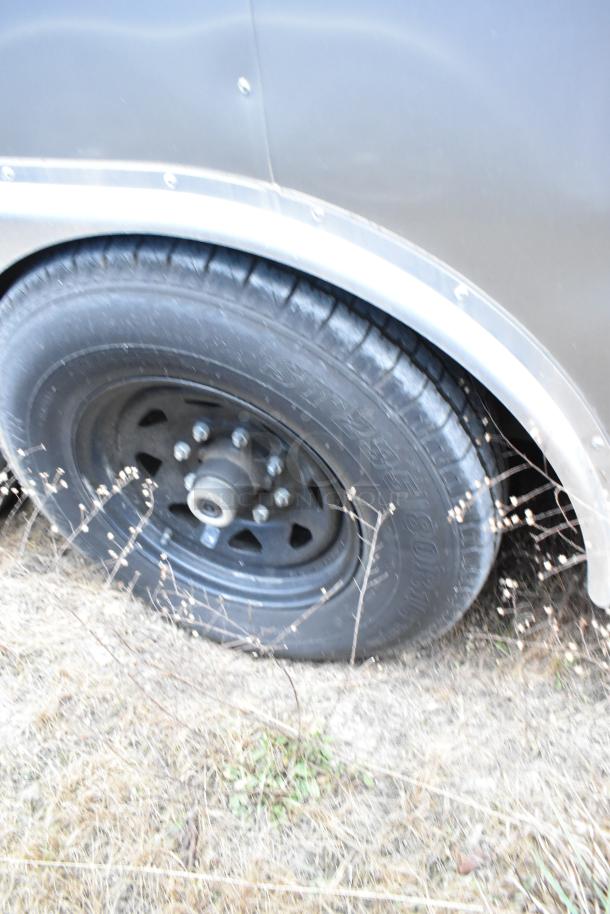Close-up of a Nationwide food trailer wheel. The trailer offers full kitchen equipment including Beverage Air coolers.