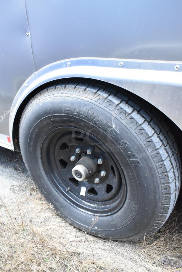 Close-up of Nationwide 24' food trailer tire, featuring "Elevate STR" marking. The trailer is fully outfitted for a mobile kitchen.