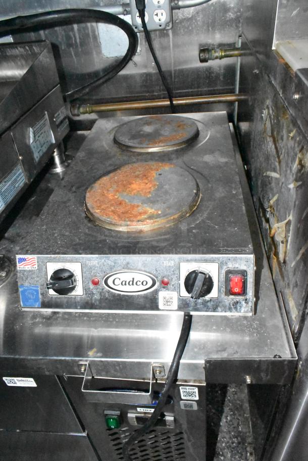 Cadco electric hot plate in used condition, featuring dual burners and control knobs. Label indicates "Made in USA."
