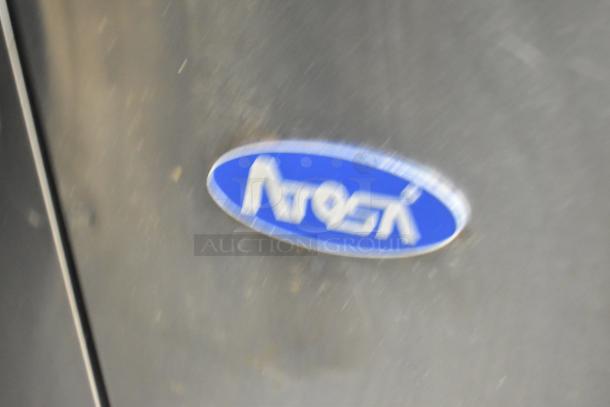 Blurry image of an Atosa logo on commercial kitchen equipment, part of a Stuff4less mobile kitchen trailer.