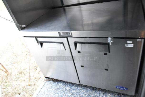 Stuff4less mobile kitchen trailer interior with Atosa pizza prep table. Stainless steel, commercial-grade equipment.