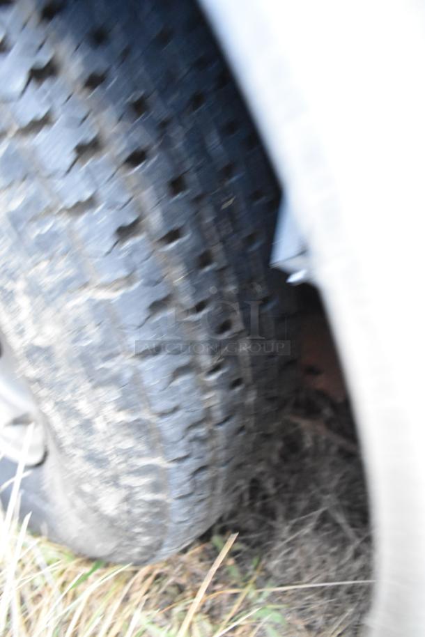 Blurred close-up of a tire on a Stuff4less 24' fast food trailer. Image lacks details of the trailer or equipment.