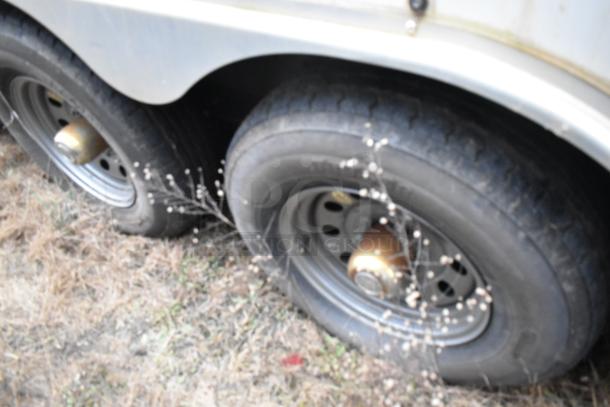 Wheels of Stuff4less 24' fast food trailer, showing dual tires in outdoor setting; part of a mobile kitchen setup.