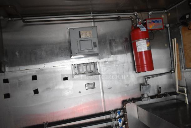 Interior of a Stuff4less 24' shell food trailer. Features include a fire extinguisher, electrical panel, and installed plumbing.