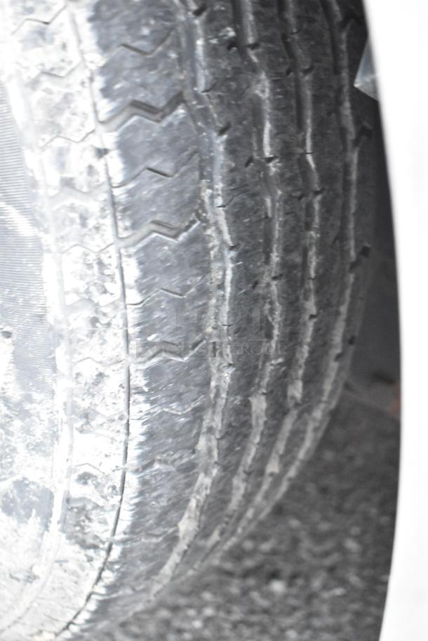 Close-up of a worn tire on a Stuff4less 24' food trailer. The trailer is new from 2019, ready for outfitting, with sinks and AC. Clear title.