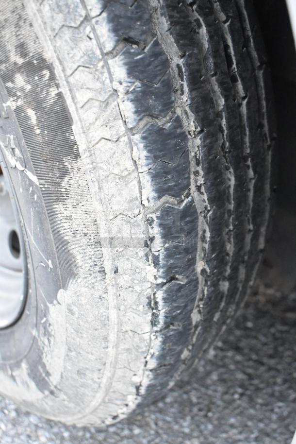 Close-up of a tire from the Stuff4less 24' unbranded food trailer. The tire shows some wear, indicating use.