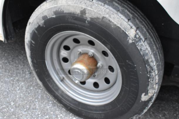 Close-up of a tire and wheel on a Stuff4less 24' shell food trailer, showcasing the durable metal wheel and tire condition.