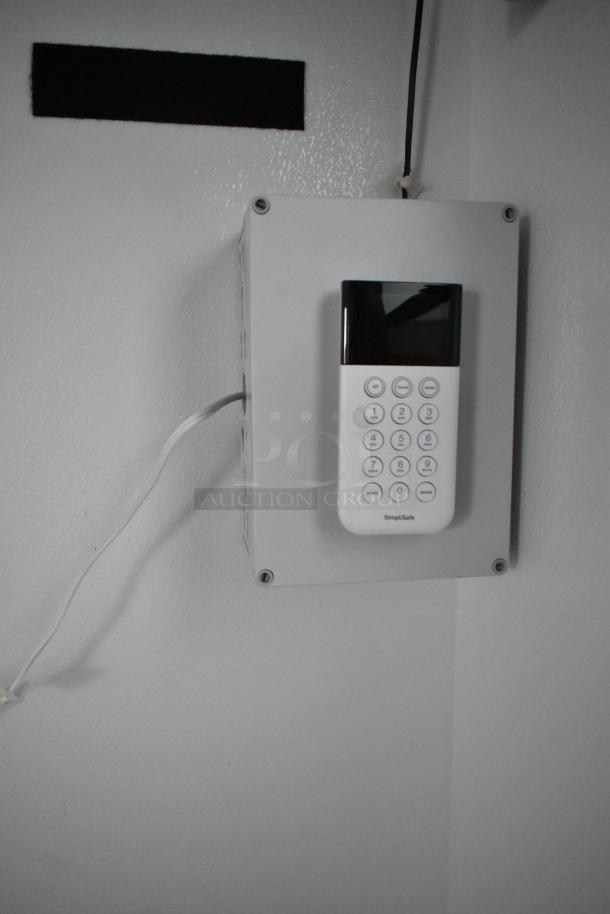 Wall-mounted security keypad inside the SDG 20' shell food trailer. Simplisafe brand, ready for equipment installation.