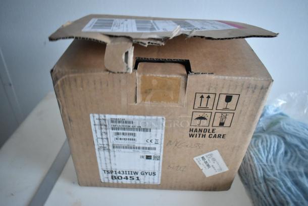 A cardboard box with shipping labels including SKU: TSP143IIIW GY US. Marked "Handle With Care." Box is slightly open.