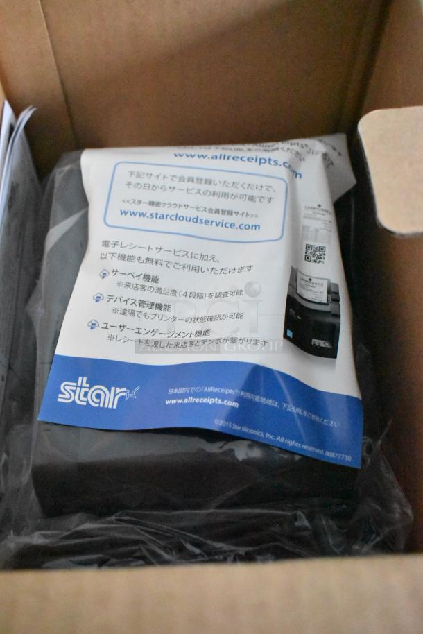 Cardboard box containing a Star Micronics device with promotional materials in a bag. Item appears new.