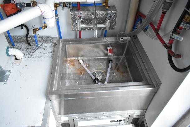 Interior of an SDG 20' food trailer showing a stainless steel sink with plumbing and additional fixtures.