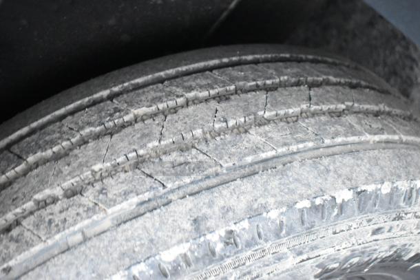 Close-up of a worn tire on an SDG 20' unbranded shell food trailer, showcasing tread wear and condition for potential buyers.