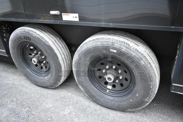 SDG 20' unbranded mobile kitchen trailer, black exterior, two durable tires shown, ready to be outfitted. Clear title.