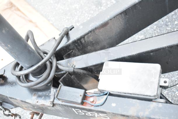 Stuff4less 24' food trailer hitch area, showing coiled cables and metal frame. Equipped with breakaway switch.