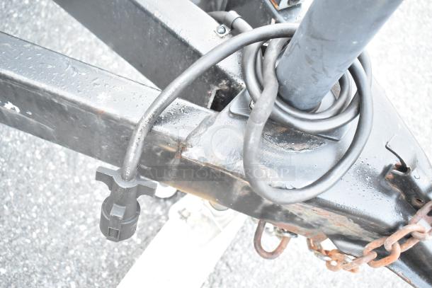 Close-up of a Stuff4less 24' food trailer hitch with power cable and chains, showing durable construction, ready for outfit.