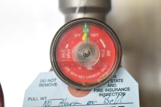 Close-up of pressure gauge marked "use with wet chemical only," showing a green zone indicator and a tag reading "do not remove."