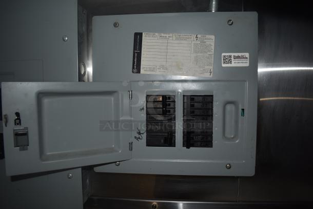 Electrical panel inside Stuff4less 24' fast food trailer. Visible breaker switches and label with safety warnings and specifications.