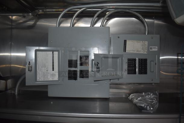 Electrical panels inside Stuff4less 24' mobile kitchen trailer, gray metal, labels indicating circuit configurations.