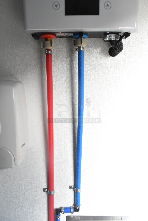 Interior of a Nationwide retail trailer with visible plumbing, featuring red and blue pipes beneath mounted equipment.