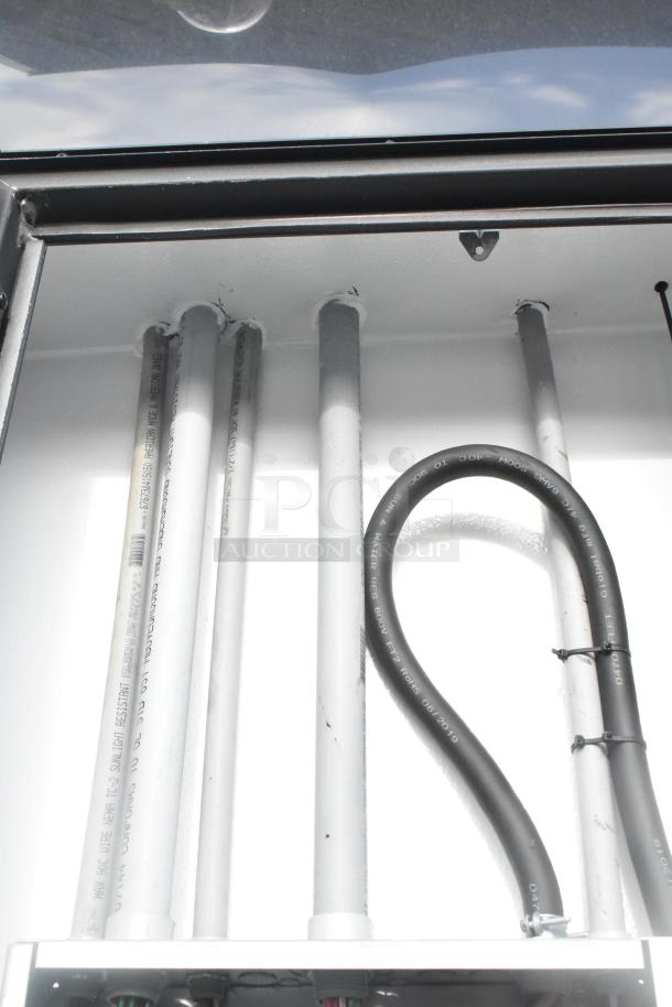 Interior view of SDG 20' unbranded shell food trailer showing plumbing and electrical fittings, ready for customization.