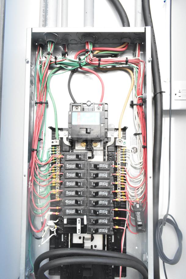 Electrical panel with wiring, breakers, and a visible digital display. Wires color-coded for organization.