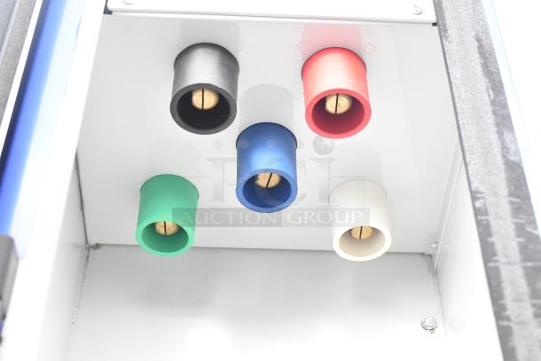 Interior view of a mobile kitchen trailer featuring a panel with five colored circular connectors: black, red, green, blue, and white.