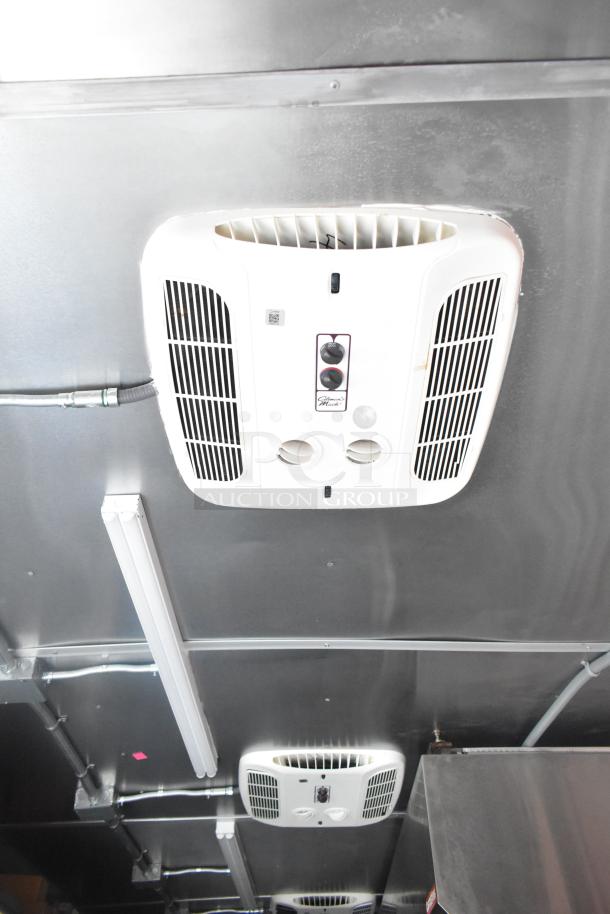 Interior view of a 2021 Rock Solid Cargo 24' mobile kitchen trailer, featuring ceiling-mounted ventilation system. Brand new condition.