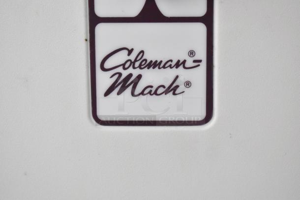 Coleman-Mach logo on white surface, showcasing brand mark.