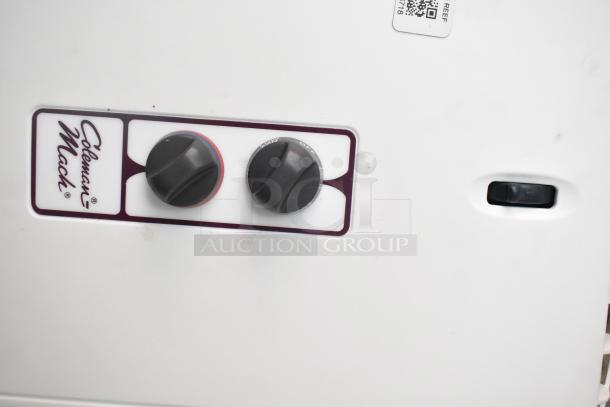 Close-up of a Coleman Mach temperature control panel with two black knobs and a white surface.