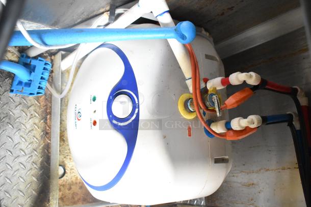 Electric water heater in Rock Solid Cargo mobile kitchen trailer, featuring blue and red piping, condition appears used.