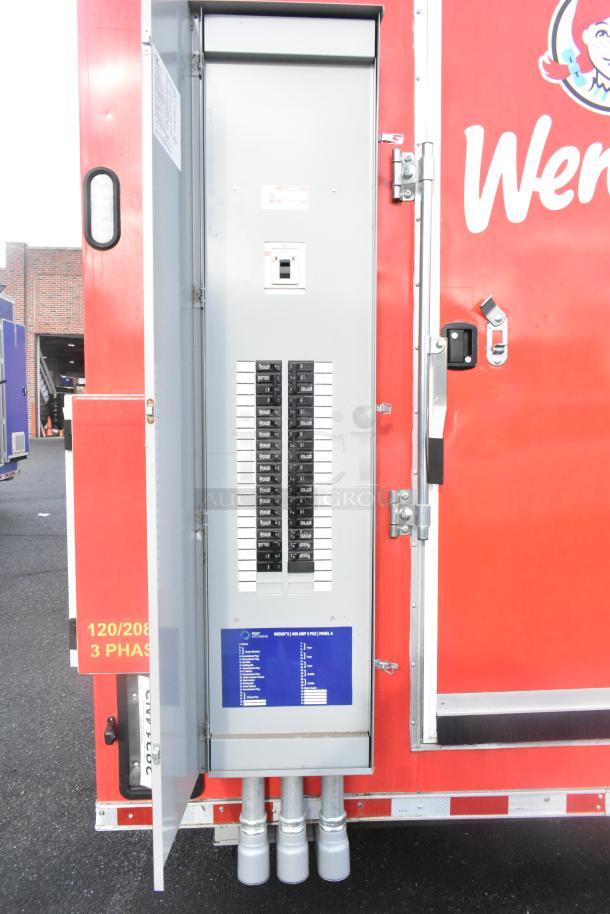 alt text: "Rock Solid Cargo 28' Wendy's Fast Food Trailer showing open electrical panel with breakers, red exterior, new condition."