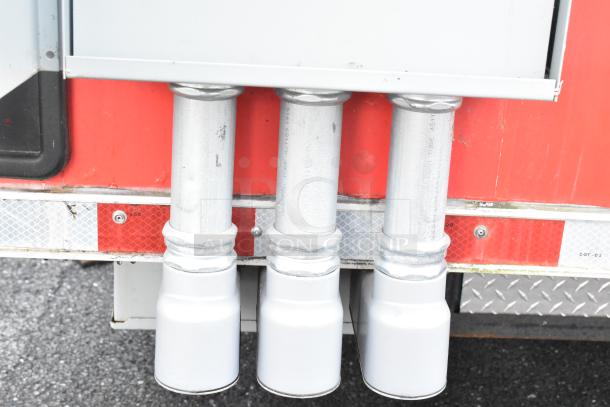 Exterior view of a Rock Solid Cargo 28' fast food trailer, featuring exhaust outlets against a red background.