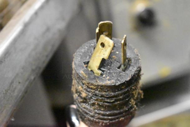 A close-up of a worn electrical plug with visible dirt and debris, likely from the Middleby Marshall PS540G pizza oven.