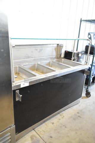 Stainless steel commercial 4 well heated buffet station with tray slide and glass shelf. Good condition, suitable for foodservice.