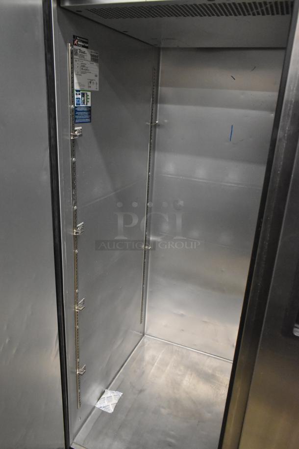 Stainless steel interior of True TG2R-2S-HC cooler with shelf brackets, label showing model info. New condition.