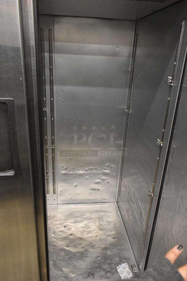2022 True TG2R-2S-HC stainless steel commercial 2 door reach-in cooler interior. Includes shelving tracks, commercial casters.