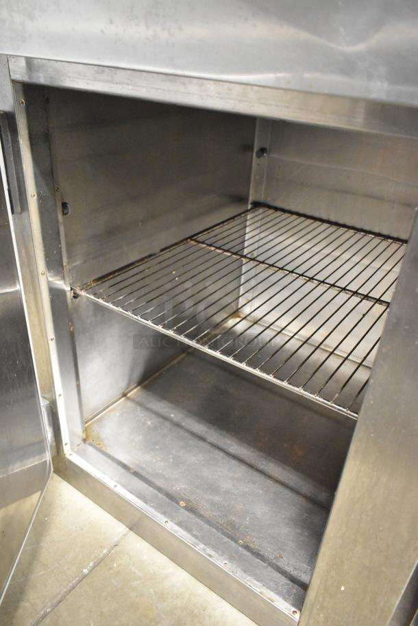 Traulsen RHT132W-HHS stainless steel commercial cooler, 2 half-size doors, reach-in, 115V, 1 phase, visible interior shelves.