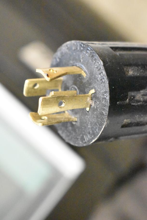 Close-up of a plug connector for a Bunn ICB SH commercial coffee machine, highlighting brass prongs and a black casing.