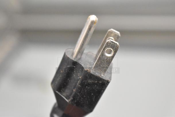 Close-up image of a three-prong electrical plug for the 2023 Avantco DPC-66-HC ice cream dipping cabinet.