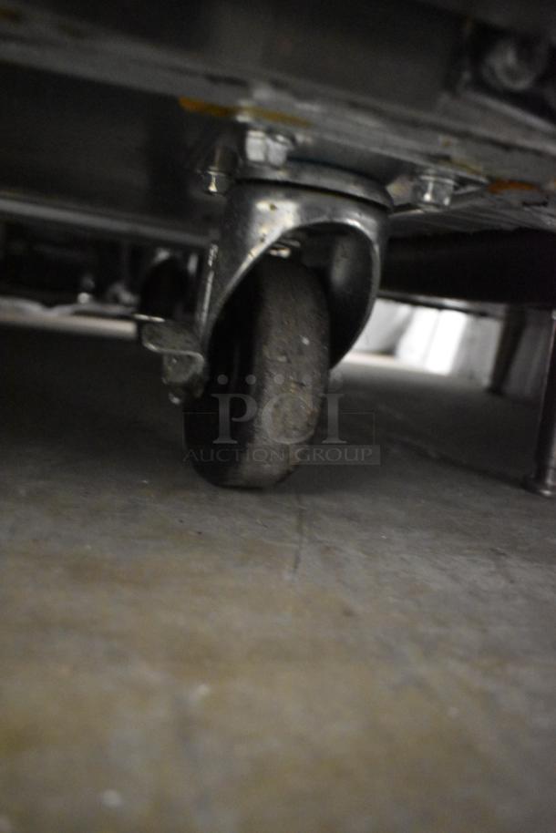 Close-up of commercial caster wheel on Avantco 178SSPT71MHC Stainless Steel Prep Table, highlighting mobility feature.