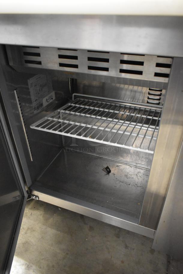 Avantco 178SSPT71MHC stainless steel sandwich salad prep table with open storage view; includes commercial casters.