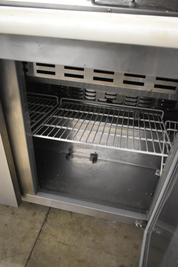 Avantco 178SSPT71MHC stainless steel prep table with open storage, commercial casters, showing interior shelving.