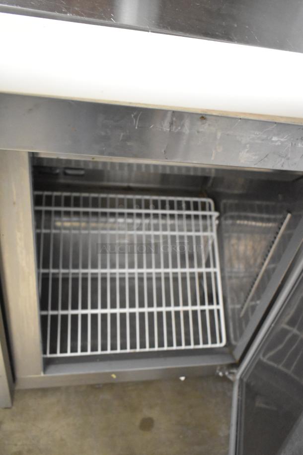 Avantco 178SSPT71MHC stainless steel prep table with open interior, wire shelves, and visible wear. Commercial casters, 115V.